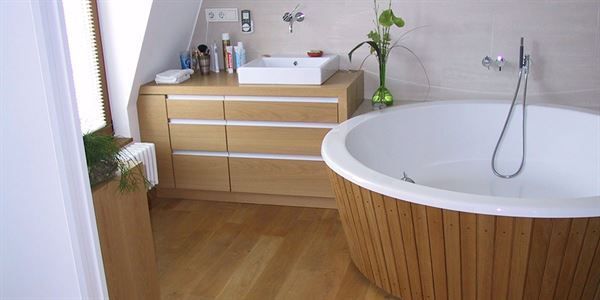 Ein Badezimmer mit einer Holzbadewanne und einem Waschbecken