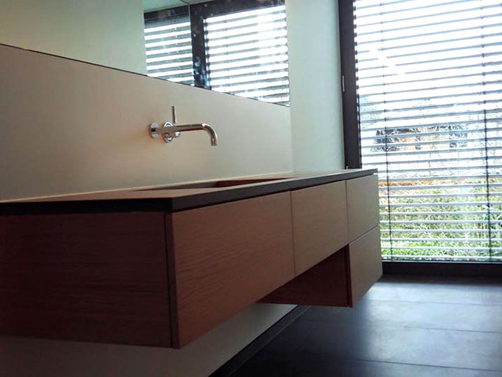 Ein Badezimmer mit Waschbecken und einem Fenster mit Jalousien
