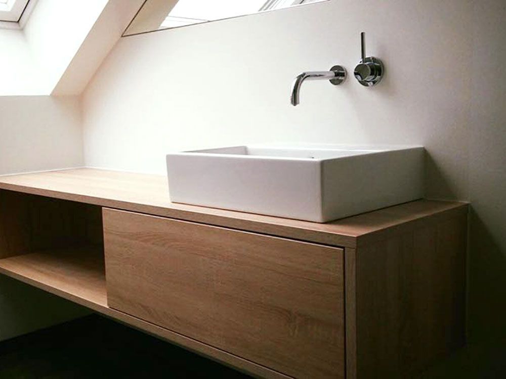 Auf einer Holztheke steht ein Waschbecken.