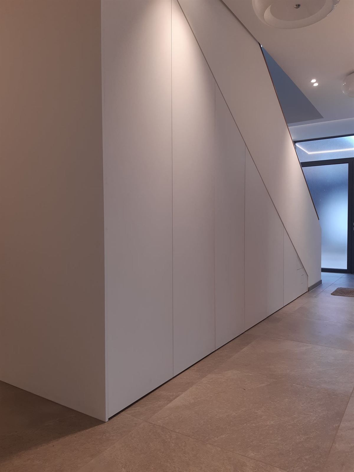Ein Flur mit einer Treppe und einer weißen Wand