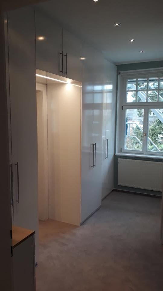 Ein Raum mit vielen weißen Schränken und einem Fenster