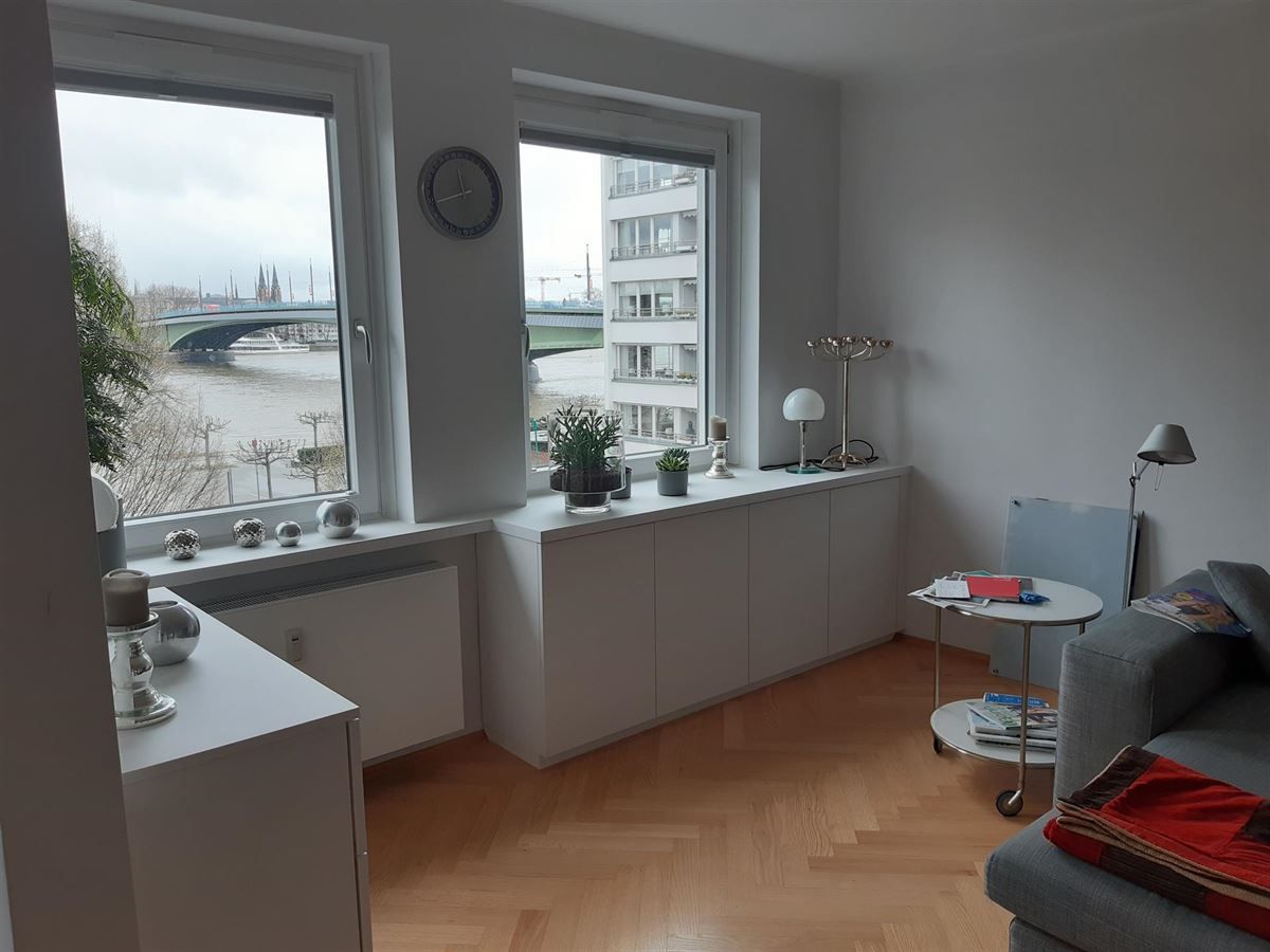 Ein Wohnzimmer mit einem Sofa und einem Tisch und einem Fenster mit Blick auf einen Fluss.