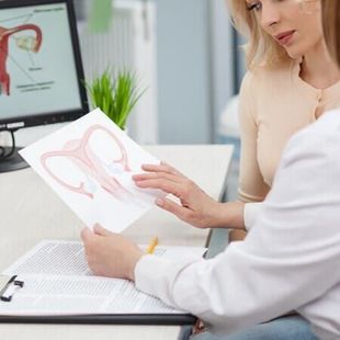 Médico revisando um diagrama do coração com um paciente em um consultório bem iluminado.