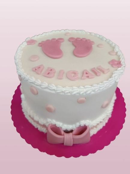 Un pastel rosa y blanco con el nombre Abigail.