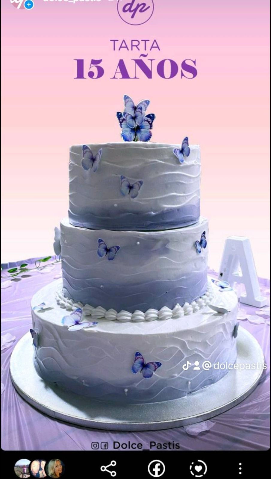 Un pastel morado y blanco con mariposas está sobre una mesa.