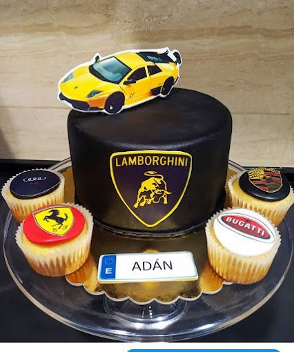 Un pastel de Lamborghini con cupcakes y un auto amarillo encima.