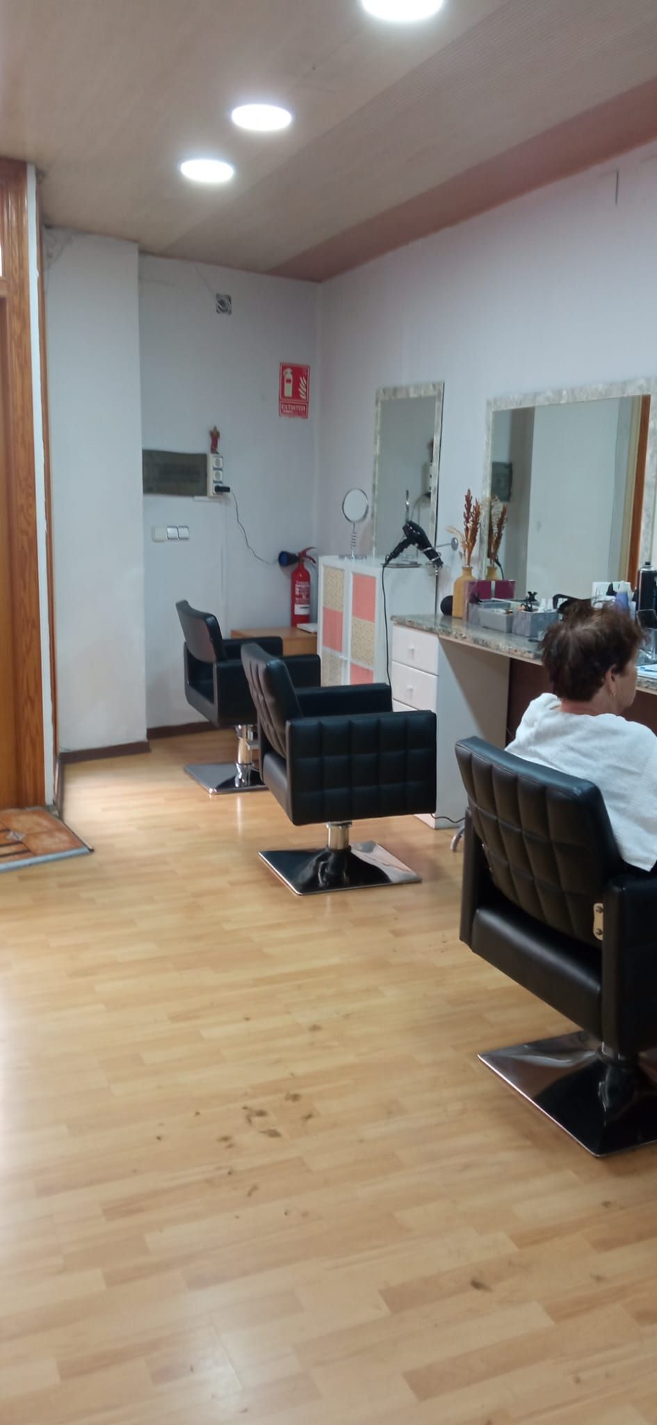 Una mujer está sentada en una silla en una peluquería.