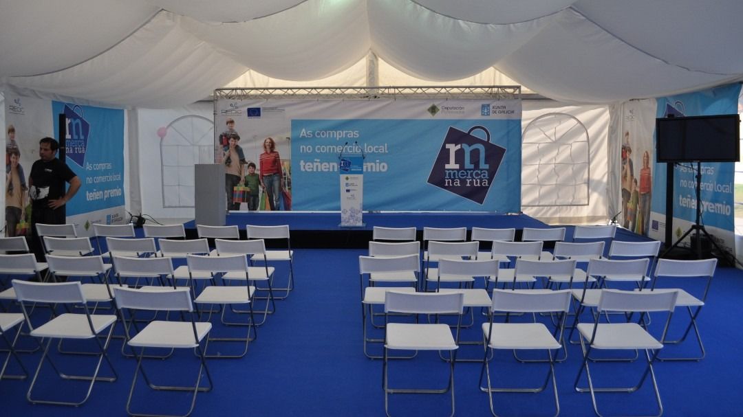 Una fila de sillas plegables frente a un escenario con un cartel que dice 10 pm
