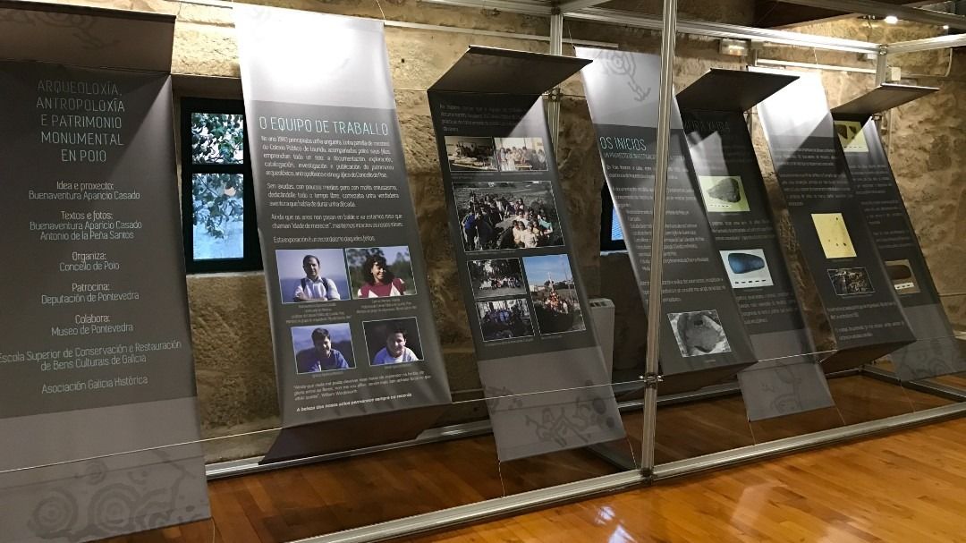 Una habitación con muchos carteles en la pared y suelo de madera.