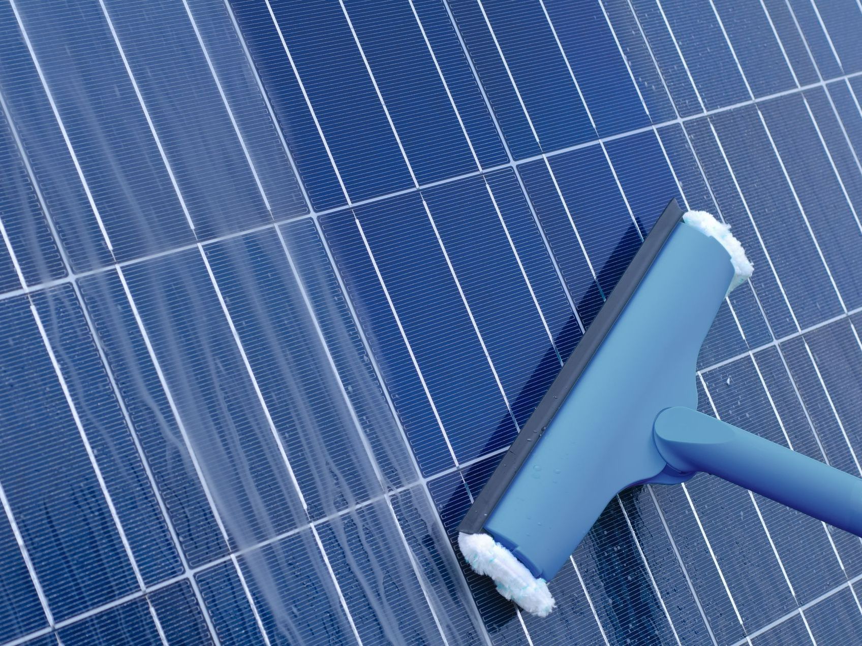 Passage d'une brosse bleue sur un panneau photovoltaïque