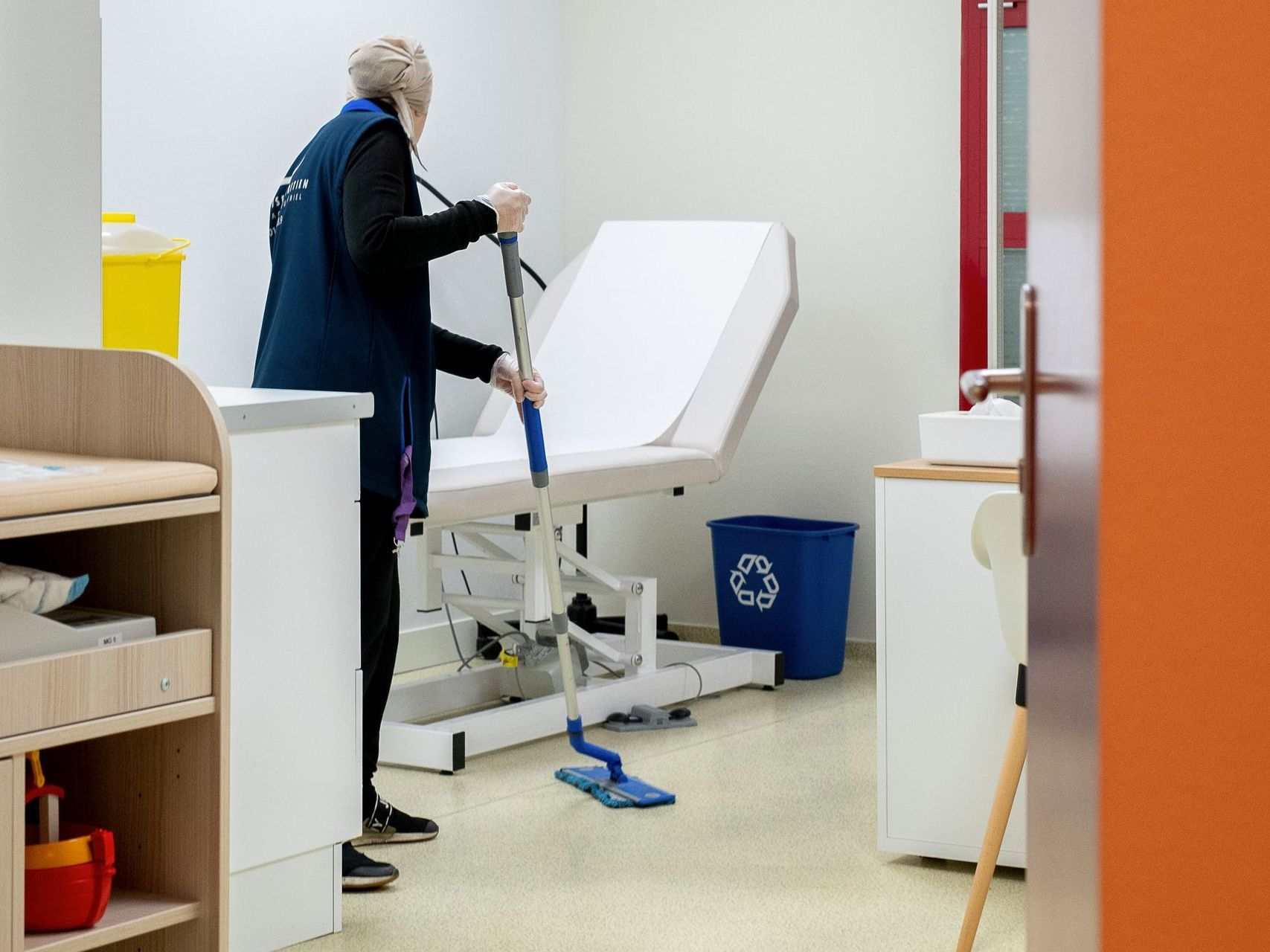 Personne qui se met du gel hydroalcoolique devant le personnel soignant