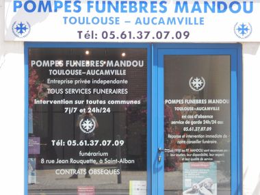 Enseigne de la maison funéraire Pompes Funèbres Mandou à Toulouse, France. Bleue et blanche, avec numéro de téléphone et services proposés.