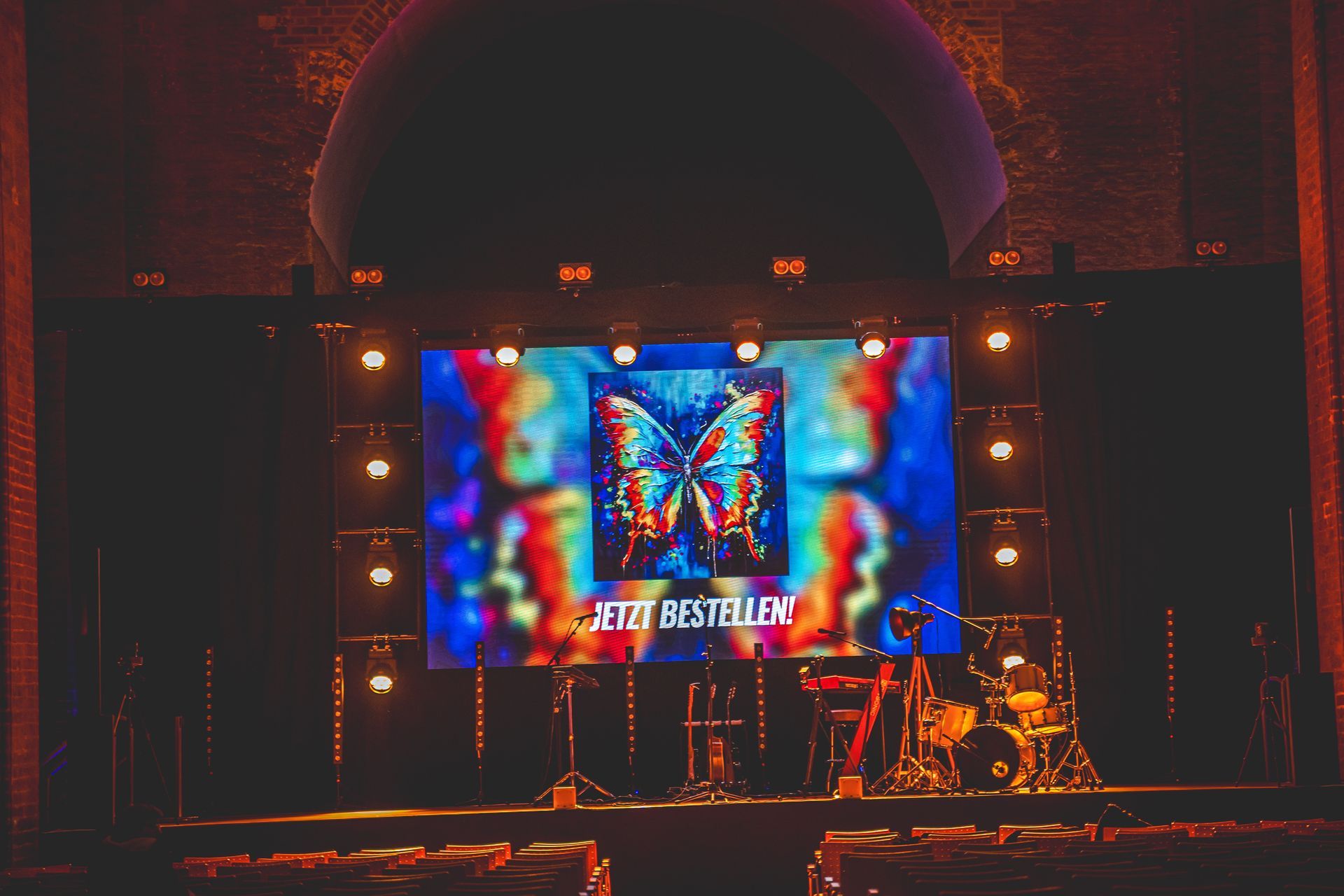 Bei einem Konzert wird auf der Bühne eine große Leinwand angezeigt.