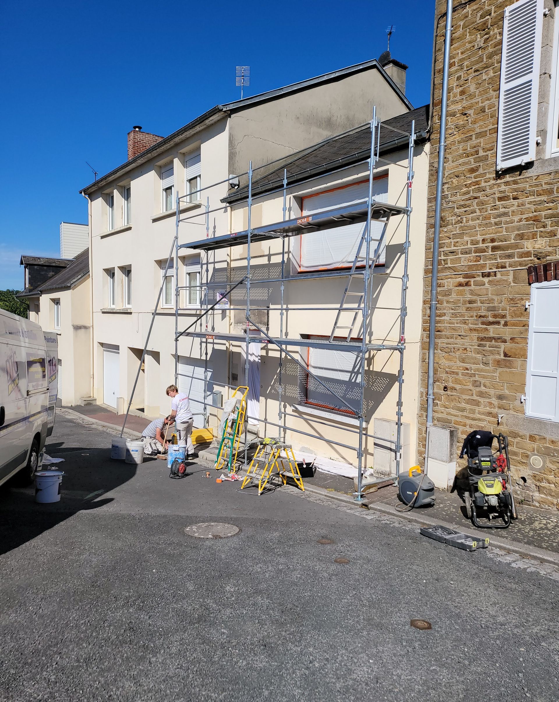 Échafaudage contre la façade d'un immeuble de 3 étages.