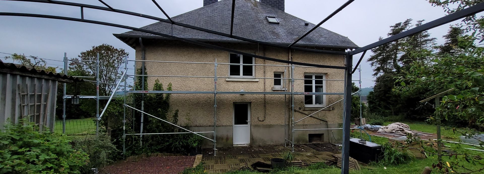 Chantier de nettoyage et réparation de façades d'une maison.