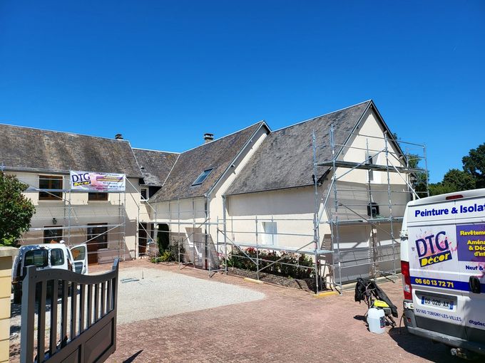 Plusieurs échafaudages sur une maison en L pour un ravalement.
