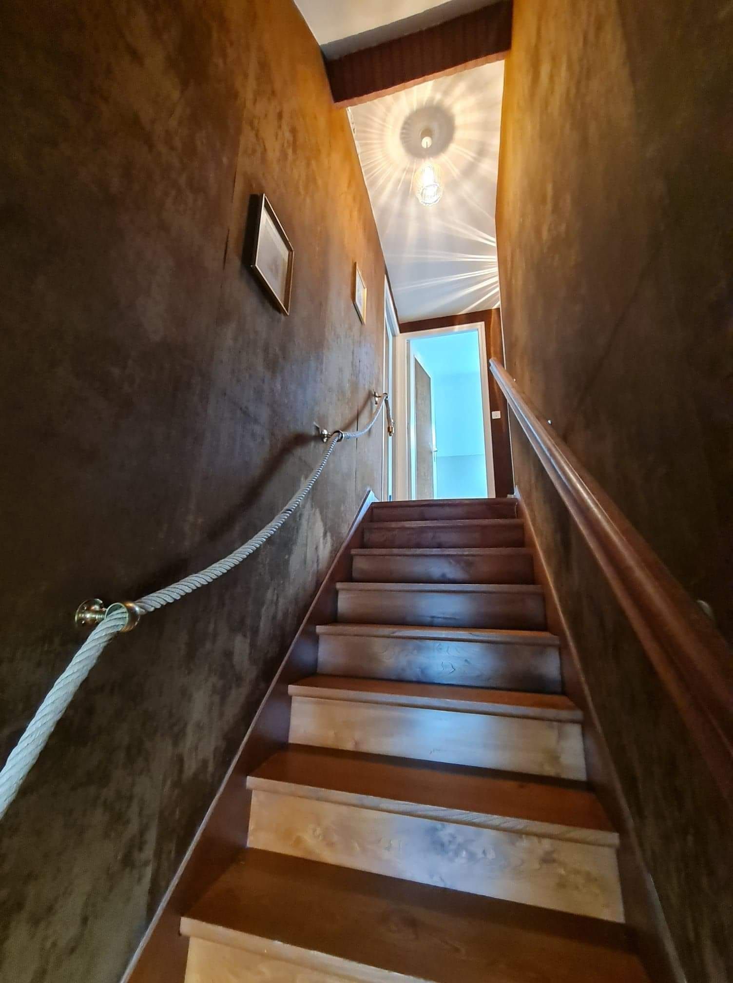 Un escalier en bois avant la rénovation des murs.