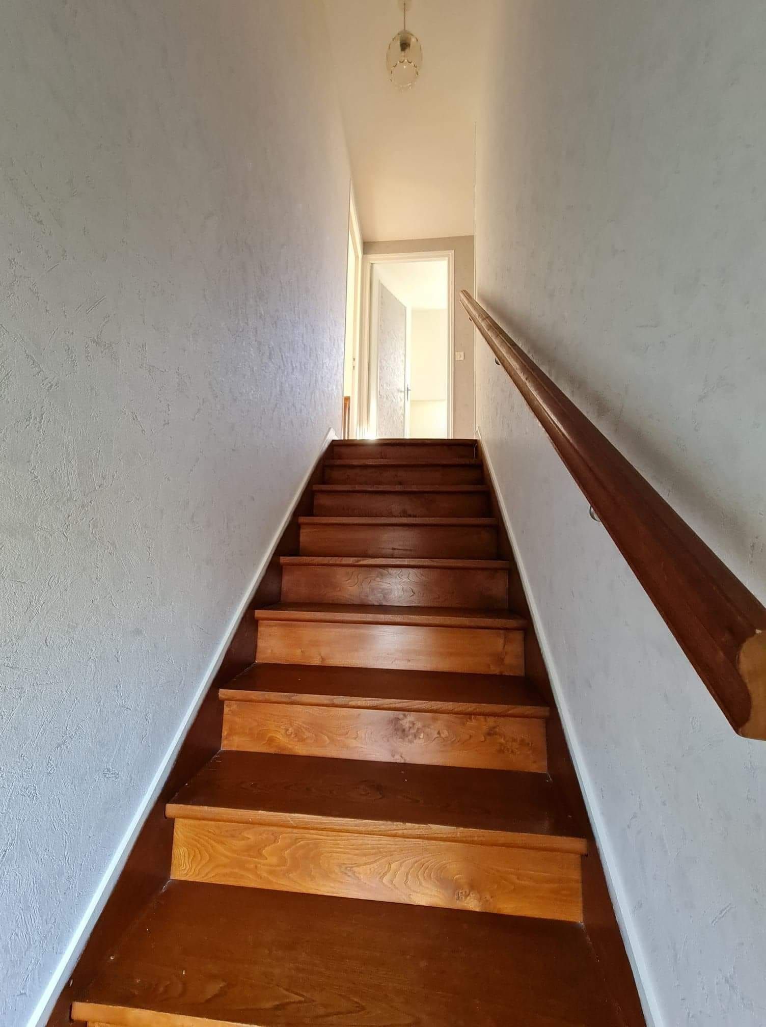 Un escalier en bois après la rénovation des murs.