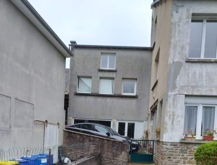 Un immeuble terne entre 2 autres avant d'être repeint.