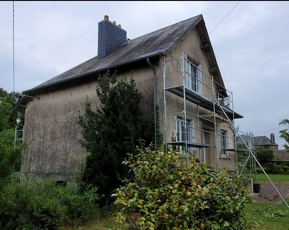 Une petite maison à étage avant des travaux de ravalement.