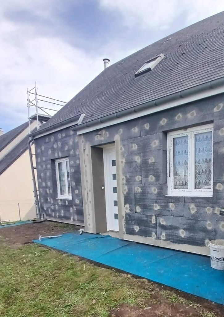 Pose d'isolant extérieur en polystyrène sur des murs en brique.