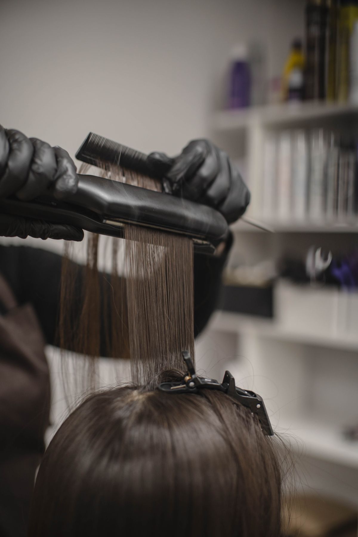 Una mujer se está alisando el cabello en la peluquería.