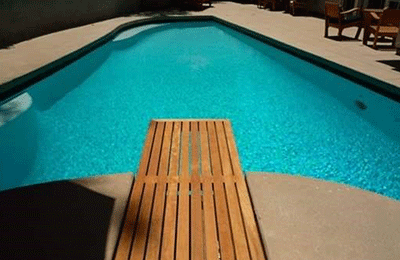 Plongeoir en bois devant une piscine
