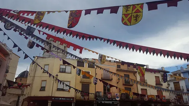 Un montón de banderas cuelgan del techo de un edificio.