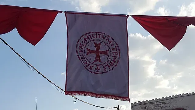 Una bandera blanca con una cruz roja y la palabra tempeli en ella