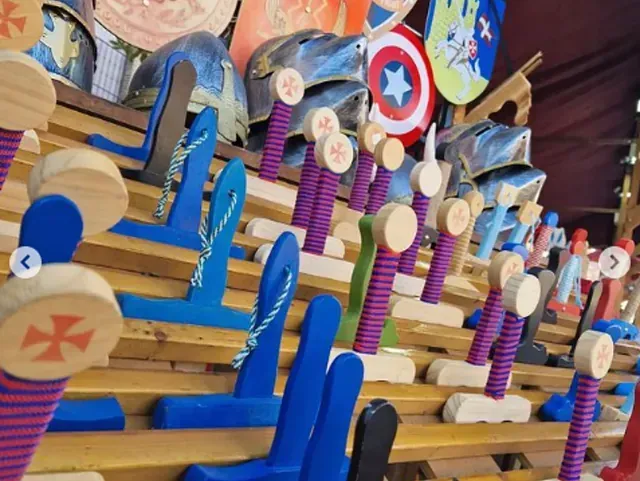 Un montón de juguetes de madera están alineados en un estante.