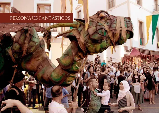 Un grupo de personas está de pie alrededor de una gran estatua de un dragón verde.