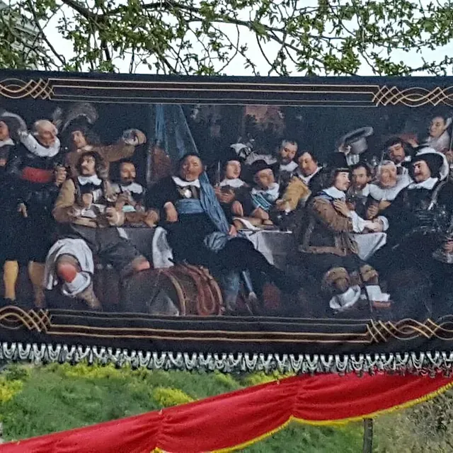 Un cuadro grande de un grupo de personas sentadas alrededor de una mesa.