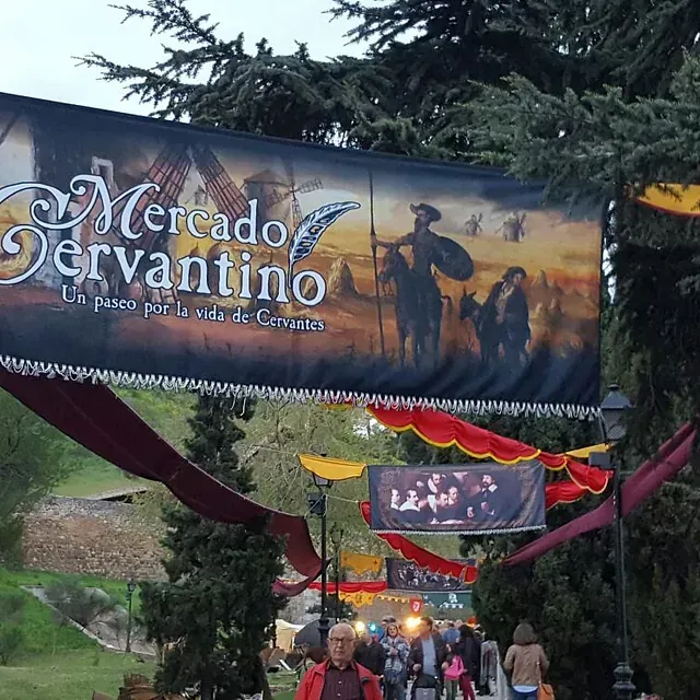 La gente camina bajo una pancarta que dice mercado jervantino