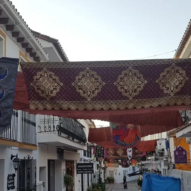 Una hilera de edificios con pancartas colgando del techo.