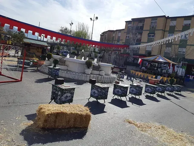 Un montón de fardos de heno están tirados al costado del camino.