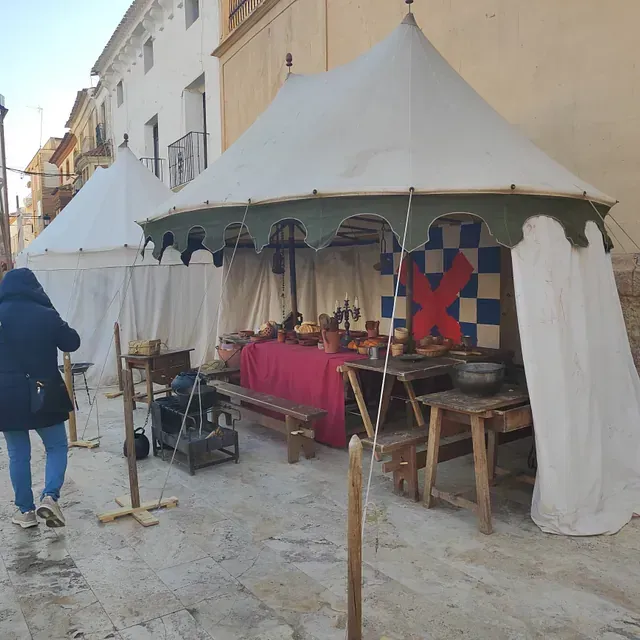 Una mujer pasa junto a una tienda de campaña con una cruz roja.