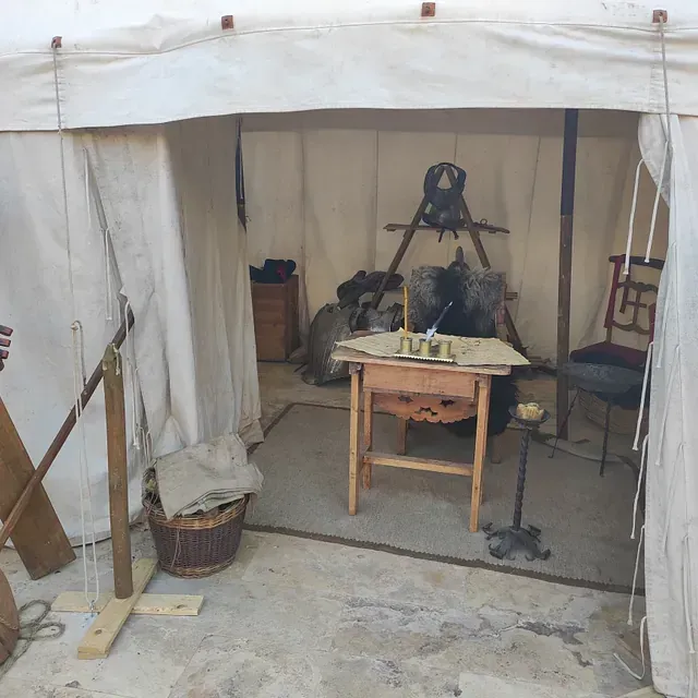 Una tienda de campaña con una mesa y sillas dentro.