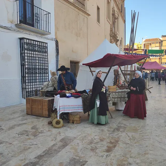 Un grupo de personas de pie alrededor de una mesa con un dosel rojo.