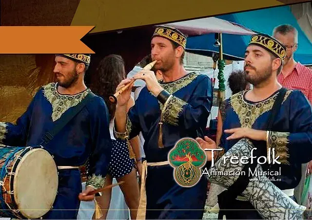 Un grupo de hombres toca tambores y una flauta frente a un cartel que dice 