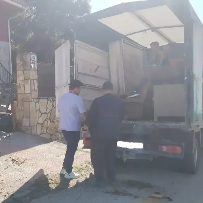 Dos personas cargando muebles en la parte trasera de un camión, probablemente para una mudanza.