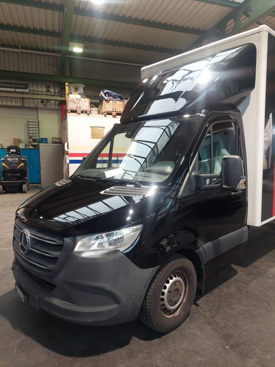 Schwarzer Mercedes-Benz Sprinter Transporter mit Hochdach in einer Garage.