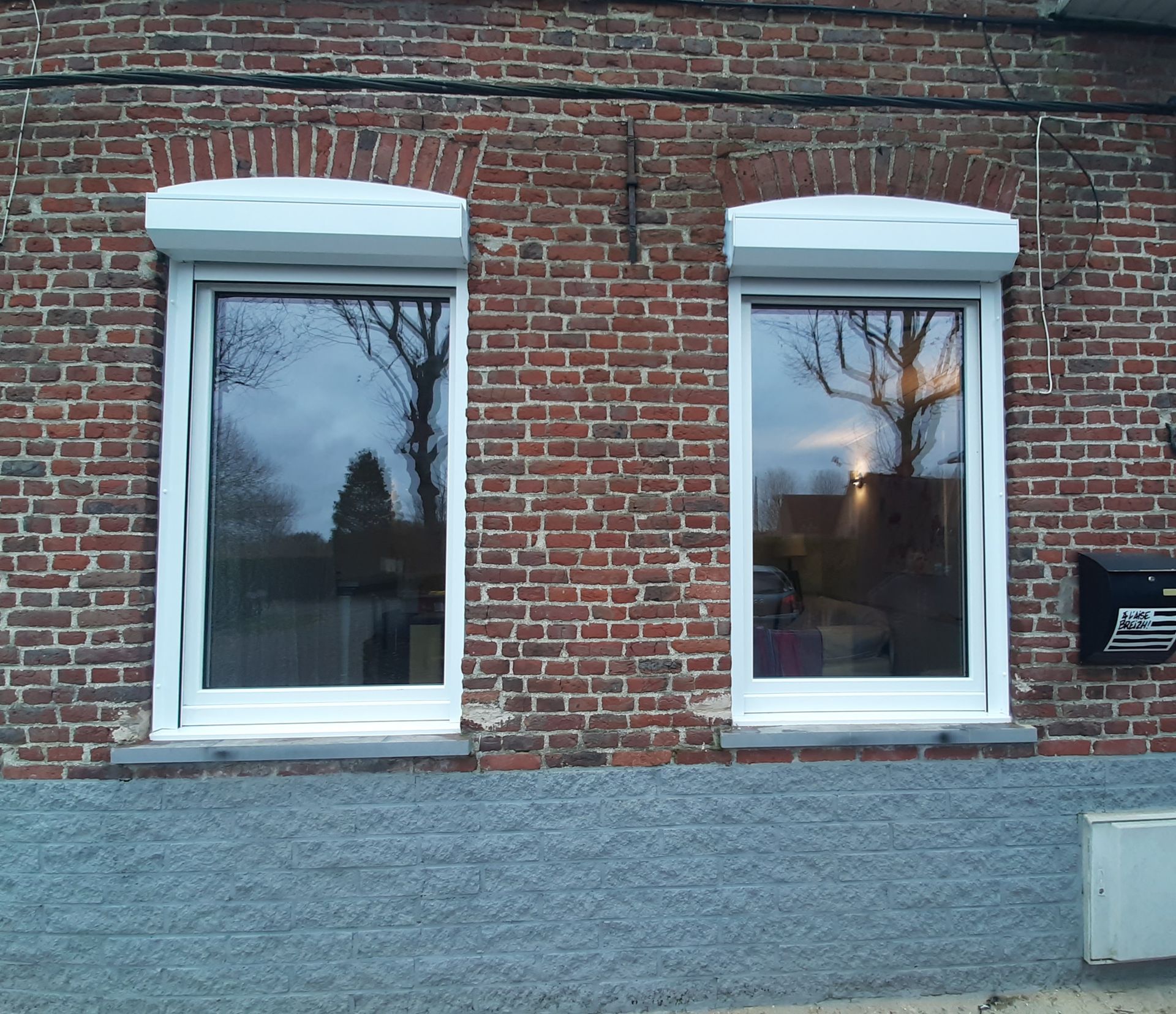 Fenêtres blanches en PVC sur façade en brique