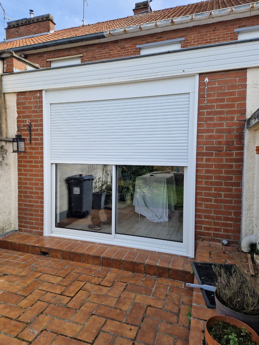 Baie vitrée avec des volets roulants ouverts à demi fermés