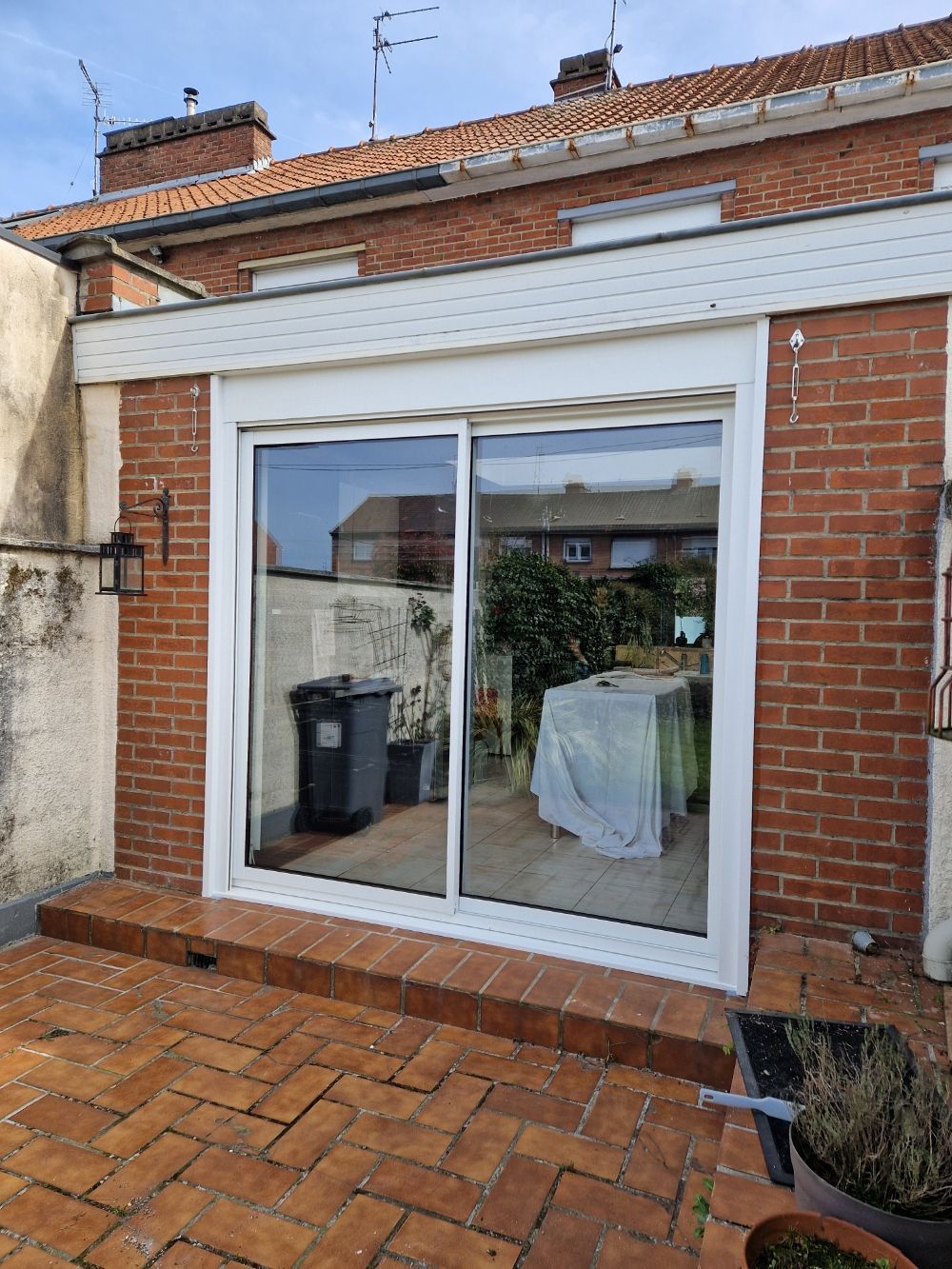 Baie vitrée avec des volets roulants ouverts