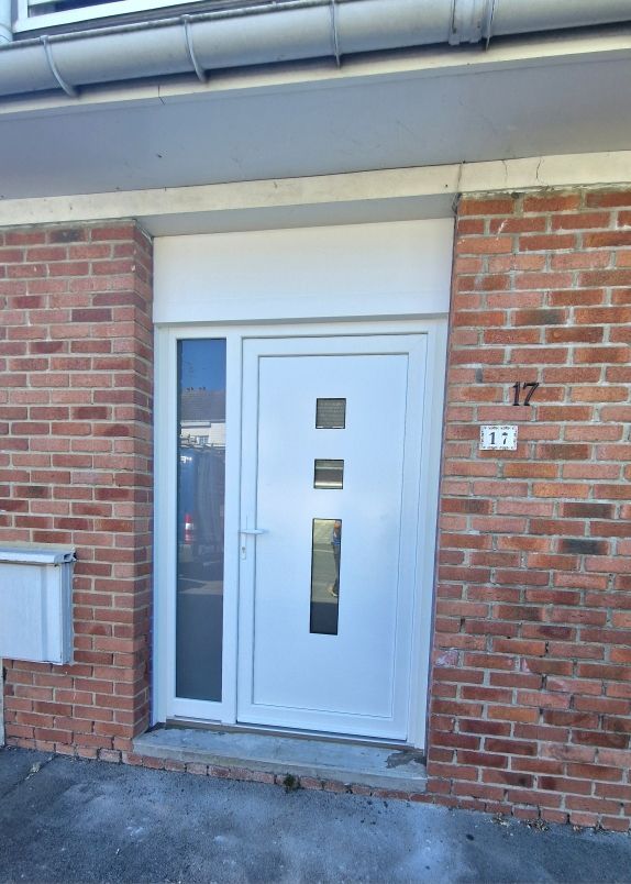 Porte d'entrée vitrée avec une grande vitre sur la gauche