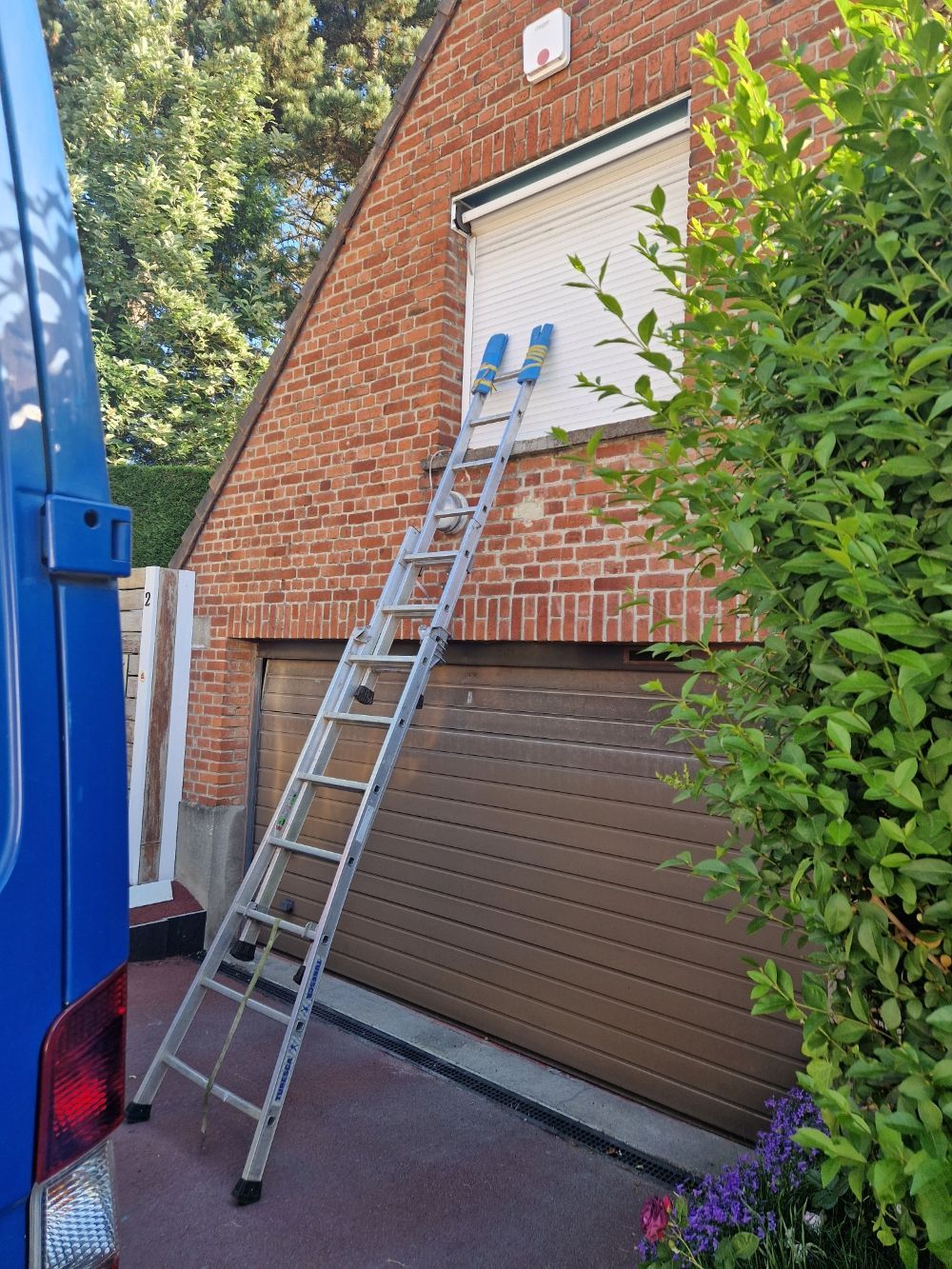 Échelle appuyée sur des volets roulants