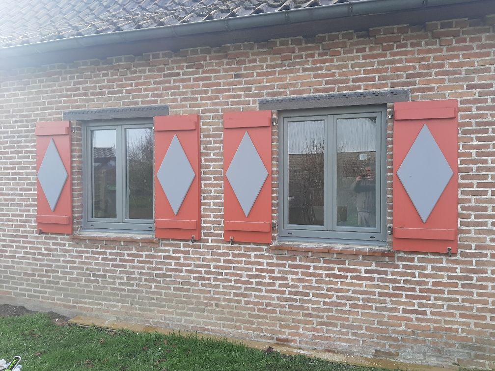 Fenêtres grises et volets battants oranges