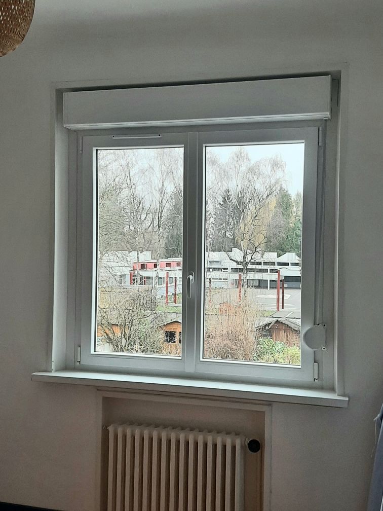 Fenêtre PVC et volets roulants au-dessus d'un radiateur