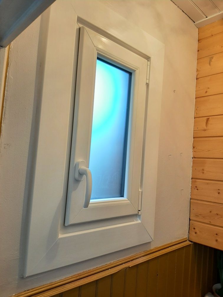 Petite fenêtre blanche entourée de lambirs