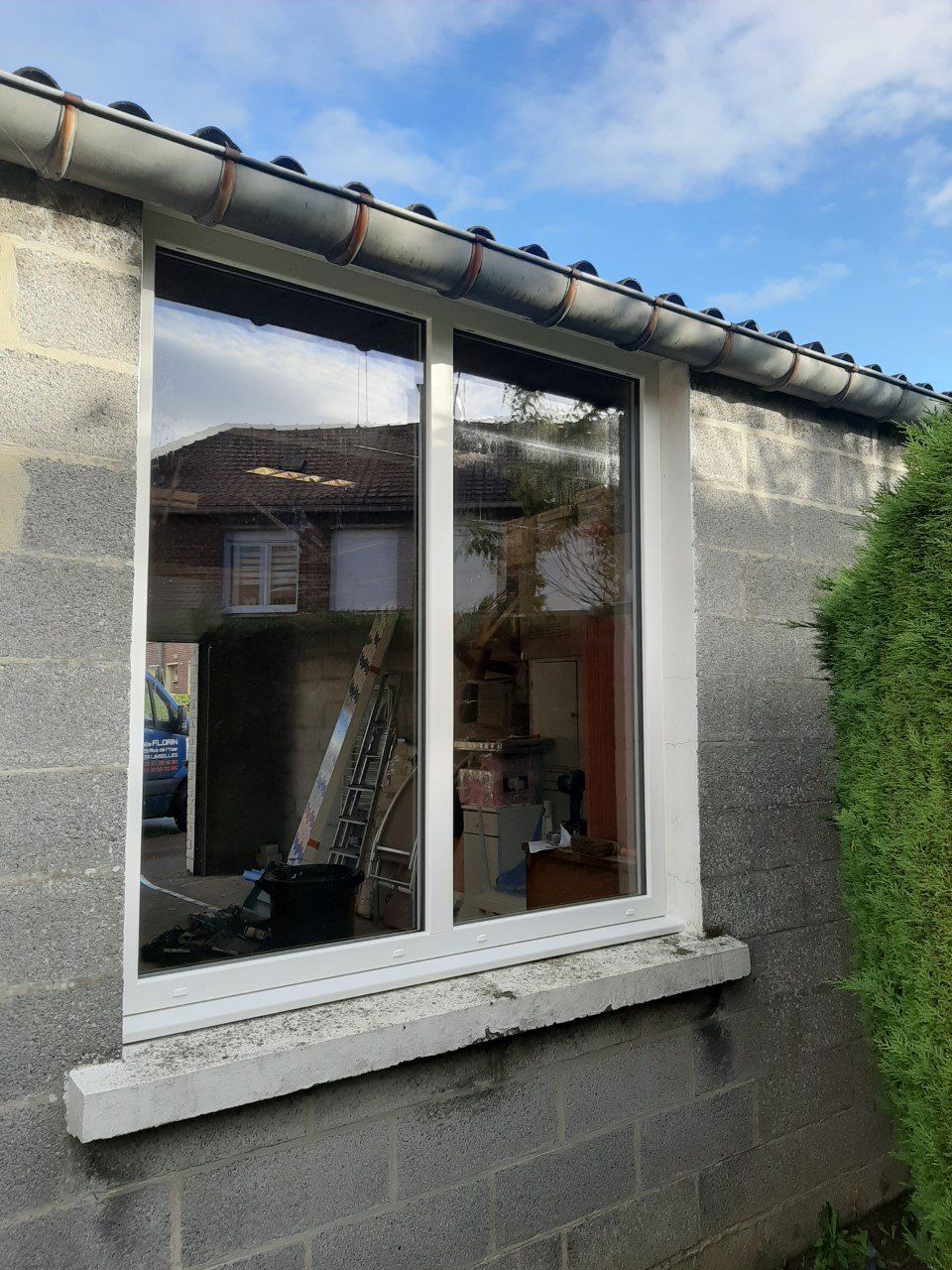 Fenêtre PVC blanche sur façade en parpaing